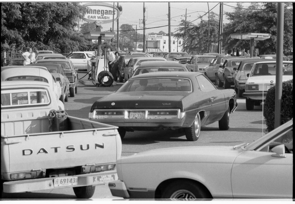 Photograph of cars in long lines waiting to buy gas. 