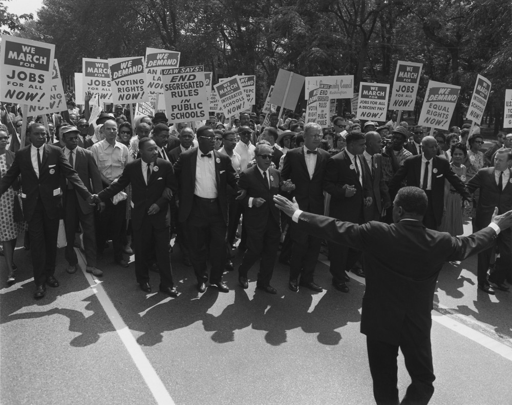 White activists increasingly joined African Americans in the Civil Rights Movement during the 1960s. This photograph shows Martin Luther King, Jr., and other black civil rights leaders arm-in-arm with leaders of the Jewish community. Signs read "We March for Jobs for All Now!" "We Demand Voting Rights Now!" "End Segregated Rules for Public Schools!" "We March for Jobs for All and a Decent Pay Now!" and "We Demand Equal Rights Now!"