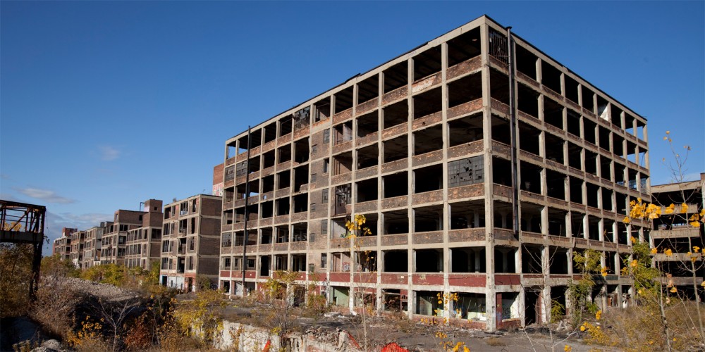 Photograph of an abandoned Packard Automotive Plant in Detroit, Michigan. Via Wikimedia.