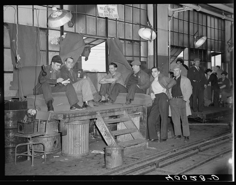 Photograph of striking workers guarding the entrance to a factory. 