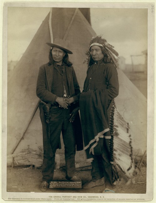 Red Cloud and American Horse – two of the most renowned Ogala chiefs – are seen clasping hands in front of a tipi on the Pine Ridge Reservation in South Dakota. Both men served as delegates to Washington, D.C., after years of actively fighting the American government. John C. Grabill, “‘Red Cloud and American Horse.’ The two most noted chiefs now living,” 1891. Library of Congress, http://www.loc.gov/pictures/item/99613806/.