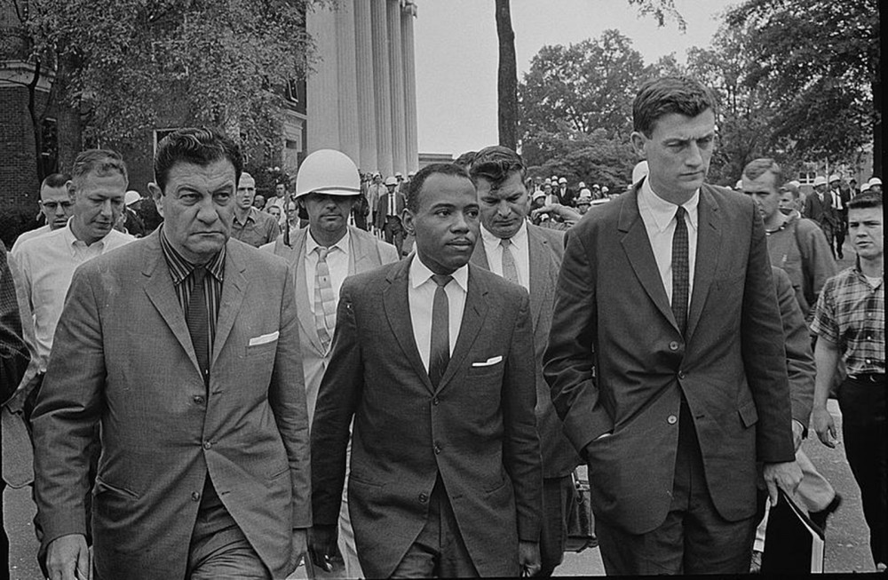 Photograph of James Meredith, accompanied by U.S. Marshalls, walking to class at the University of Mississippi in 1962. Meredith was the first African-American student admitted to the still segregated Ole Miss. Marion S. Trikosko, “Integration at Ole Miss[issippi] Univ[ersity],” 1962. Library of Congress, http://www.loc.gov/pictures/item/2003688159/.