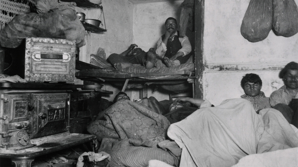 This Jacob Riis photograph shows a family crowded into a small, dirty tenement home. 