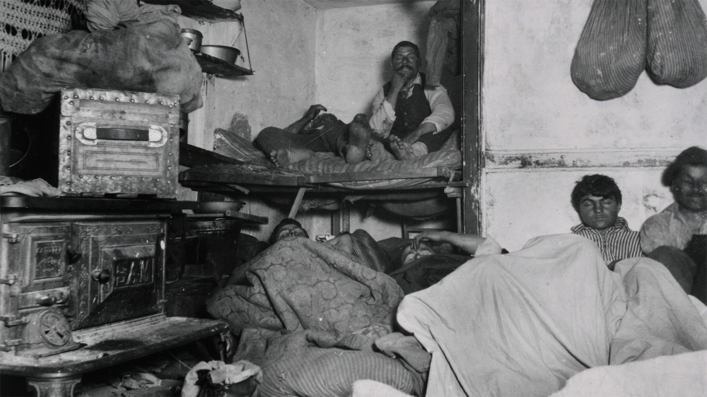 This Jacob Riis photograph shows a family crowded into a small, dirty tenement home.