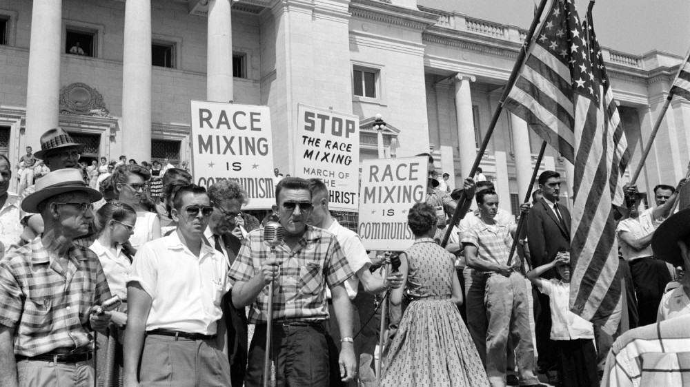 Photograph of white anti-integration protestors. Signs read "Race mixing is communism" and "Stop the Race Mixing March of the Antichrist."