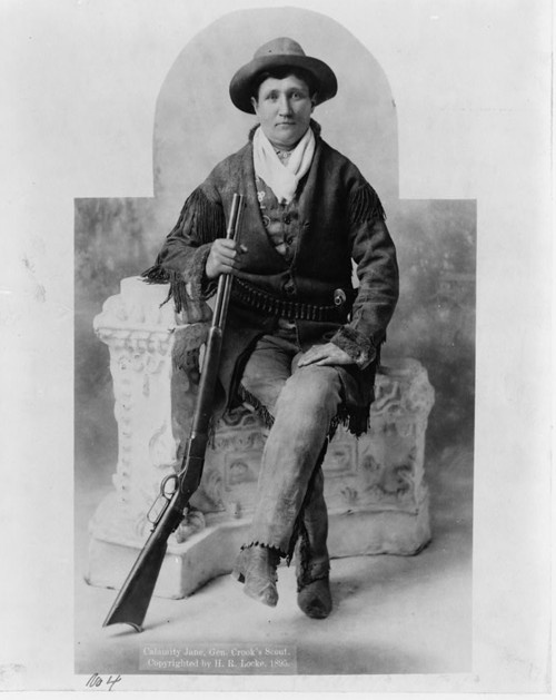 Photograph of Calamity Jane, full-length portrait, seated with rifle. 
