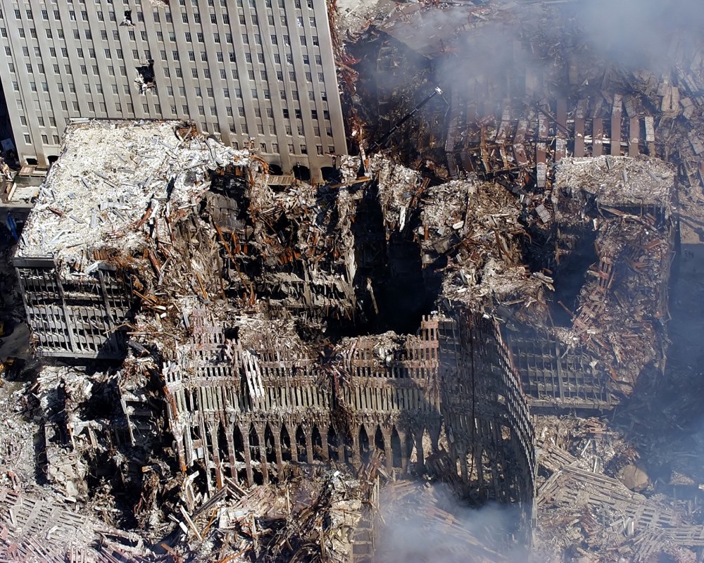 Photograph of the smoldering ruins of the twin towers six days after the September 11th attacks.