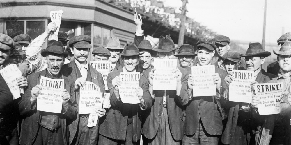 Striking steel mill workers holding bulletins that say STRIKE! 
