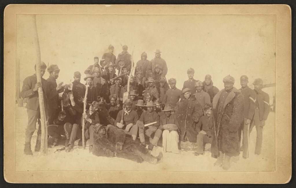 A group picture of Black soldiers, many clothed in buffalo robes.