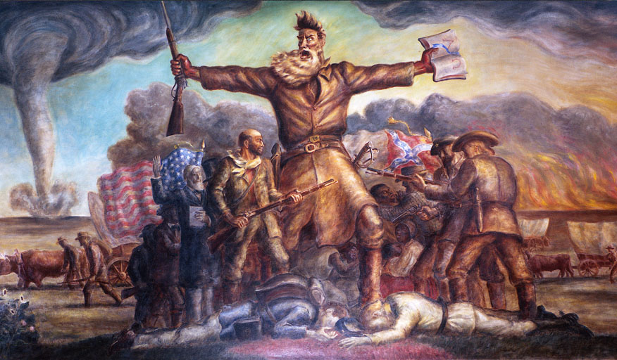 John Steuart Curry, Tragic Prelude, 1938-1940, Kansas State Capitol. A dramatic mural depicting John Brown. He is large, muscular in frontier clothing with arms outstretched, holding a rifle in one hand and papers in the other. Around him are various figures representing both pro-slavery and anti-slavery settlers. The scene includes American flags and a stromy sky. 