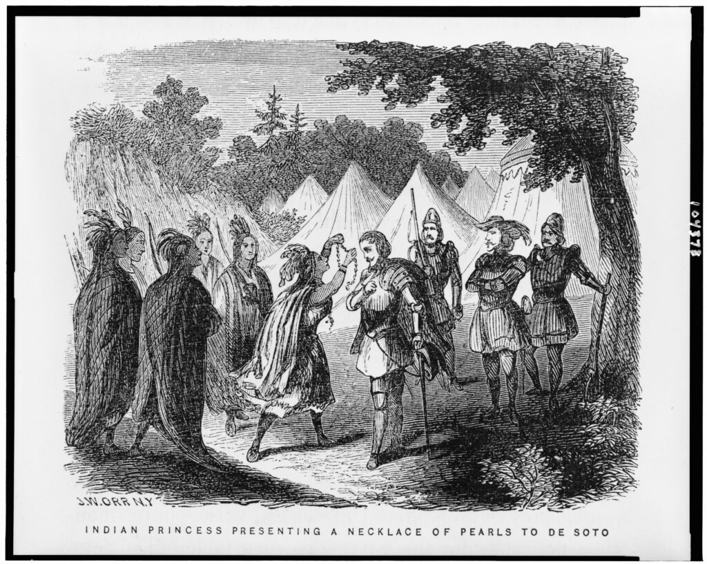 Indian princess presenting a pearl necklace to Hernando de Soto during his journeys to South Carolina, 1500-1542. Engraved by John William Orr, 1858. The image reflects a romanticized depiction of early contact between Indigenous peoples and European explorers. The black and white illustration shows a Native American woman, identified as an "Indian Princess," presenting a necklace of pearls to Spanish explorer Hernando de Soto. The scene takes place outdoors near a group of tents, with a forest in the background. The woman is surrounded by other Native Americans, while de Soto stands among several armored Spanish soldiers. The caption beneath the image reads: “Indian Princess Presenting a Necklace of Pearls to De Soto.” 
