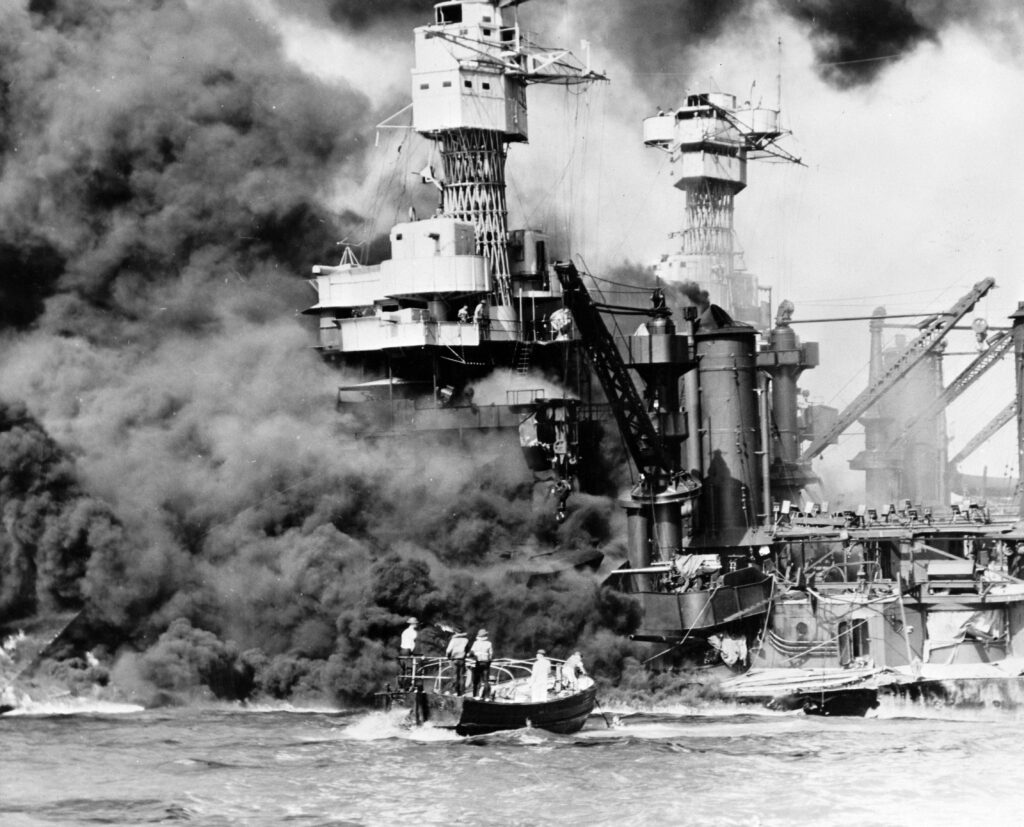 A large military ship burns.